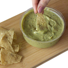 Load image into Gallery viewer, A hand dipping a nacho in Mad Mexican Roasted Tomatillo and Avocado Salsa