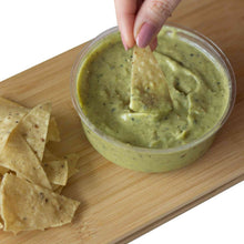 Load image into Gallery viewer, A hand dipping a nacho in Mad Mexican Roasted Tomatillo and Avocado Salsa
